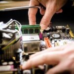 Expert repairing UPS circuit board with soldering iron for power backup system maintenance