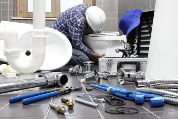 Professional plumber fixing bathroom pipe with tools, ensuring reliable solutions and smooth renovation process.
